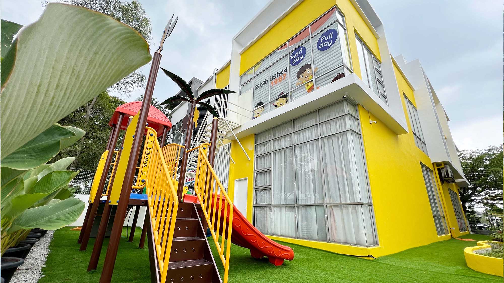 Eduwis Kindergarten in Seri Kembangan with a vibrant yellow building and outdoor playground, providing a fun, enriching learning environment for children.
