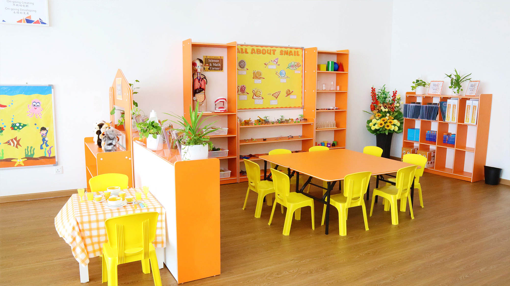 Bright and inviting Eduwis classroom setup with orange and yellow decor, tables, and educational displays at preschool in Shah Alam.