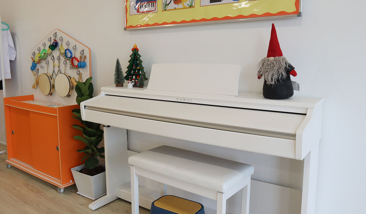 A grand white piano decorated with Christmas ornaments in a preschool
