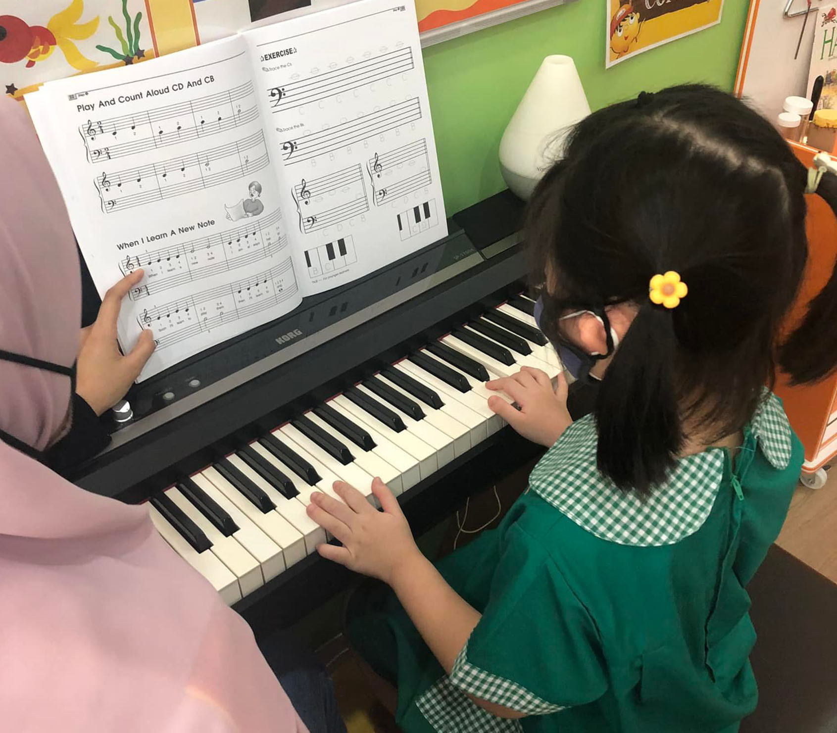 A young preschool girl in Ipoh is being taught how to play the piano & A little boy playing the piano.